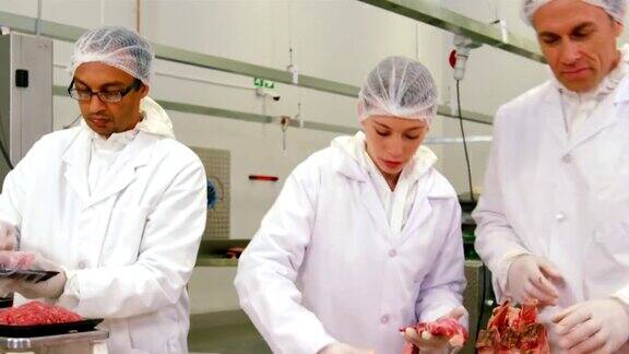 屠夫在肉品工厂包装和检查肉类的重量