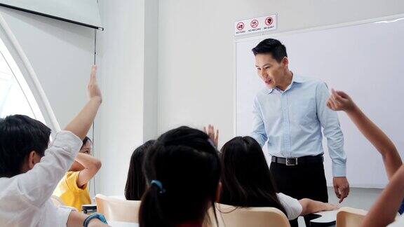 老师在学校向学生提问学生在课堂上举手教育