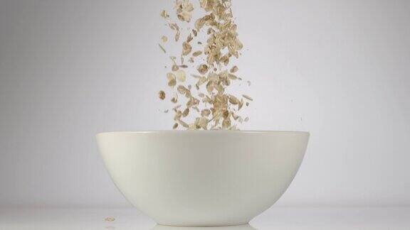 慢镜头:燕麦片掉在盘子里落在桌子上