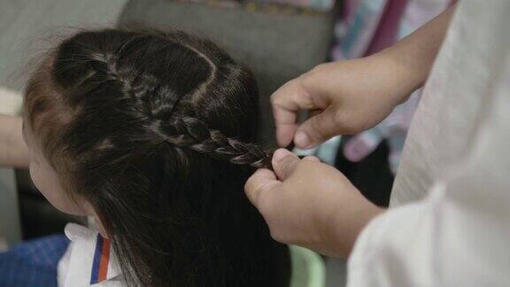 母亲在上学前给女儿编头发