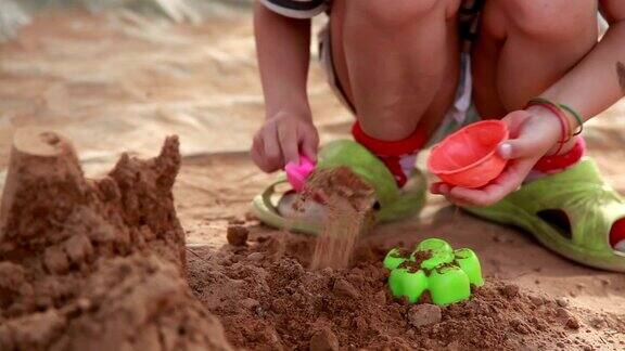 一个在后院玩沙子的孩子的手特写