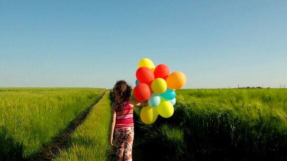 孩子带着气球在麦田小道走远