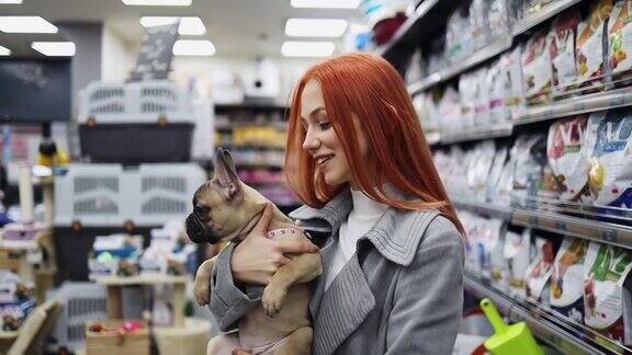 年轻女子在宠物店和她的狗