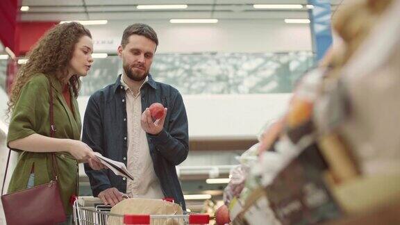 年轻夫妇在超市买水果