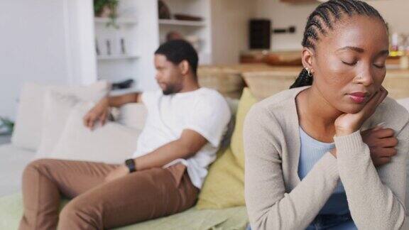 这是一对年轻夫妇在争吵后坐在家里的沙发上无视对方的4k视频