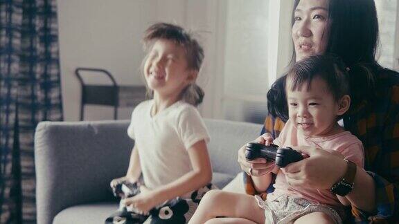亚洲母亲和女儿玩电子游戏(慢动作)