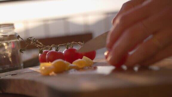 女性用手切樱桃番茄