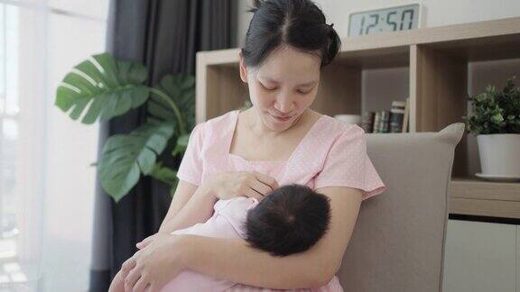 年轻的亚洲母亲正在哺乳她的孩子