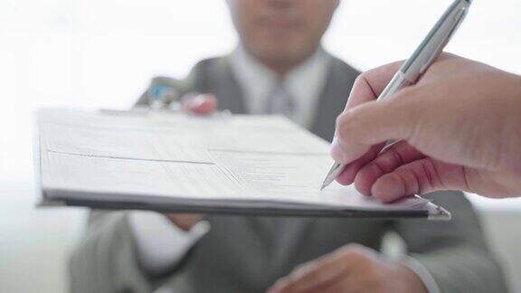 签订商业合同一名商人递上一支笔在一份商业合同上签字4k决议
