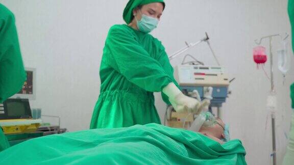 医院手术室的一组医生亚洲专业的外科医生和护士团队为重症监护患者实施心肺复苏术并在手术中使用除颤器电击心脏
