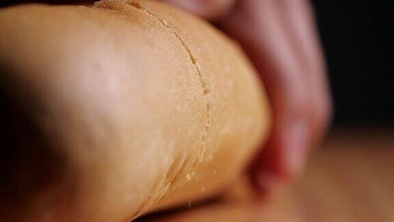 厨师用面包屑在木板上切面包的特写镜头用慢动作切面包