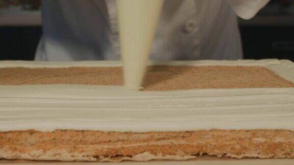 糕点师将黄油奶油涂在蛋糕上