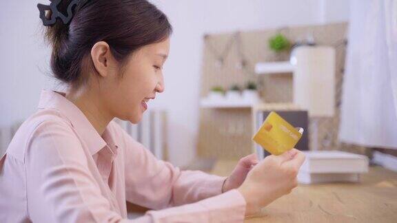 亚洲女性用手机和信用卡在网上购物
