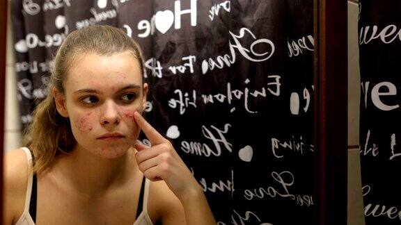 十几岁的女孩在浴室里往脸上涂抹精油