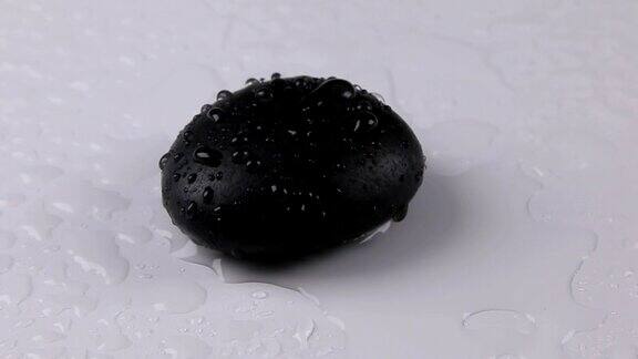 水滴落在黑色的石头上在白色的背景上