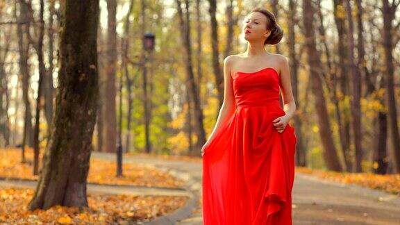 穿着红色裙子和漂亮的红色时尚鞋的女人走在公园里像公主一样