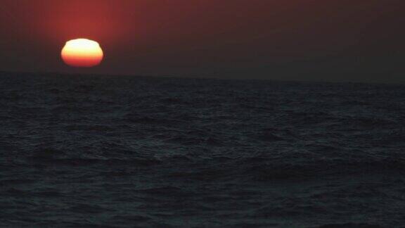从一艘船的舷窗望去是平静的日落的海面