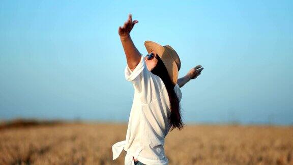 快乐的旅行女性在白衬衫举起手享受自由包围麦田