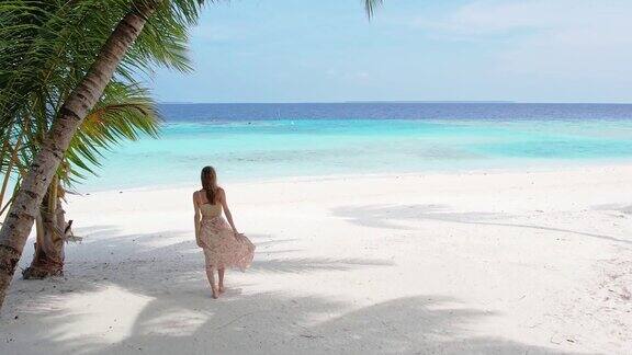 美丽的女人走在热带海滩