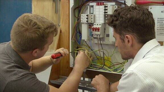 教师帮助学生培训成为电工