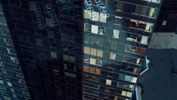鸟瞰图镜头:从外面到办公大楼与商人工作和看窗外美丽的飞离拍摄的金融商业区摩天大楼在晚上
