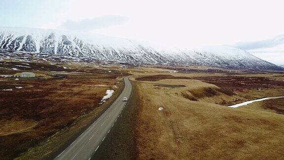 鸟瞰图:在冰岛美丽的道路上跟随一辆白色SUV汽车