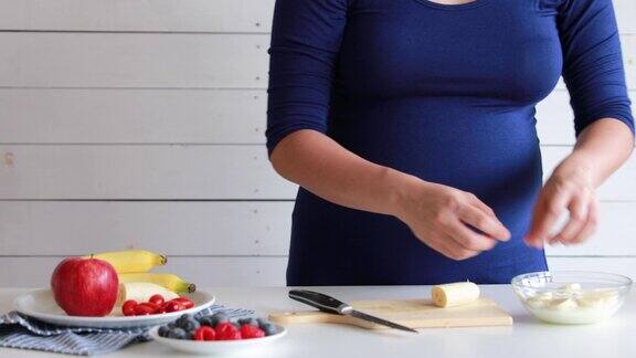 孕妇烹饪和切水果用于水果搅拌机健康