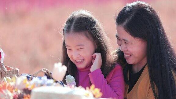 SLOMO美丽的小女孩和她的妈妈在户外公园吃零食