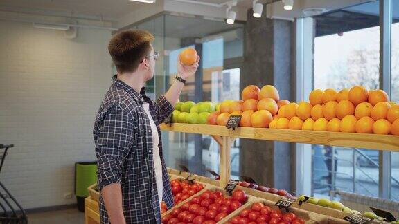 一名男子在超市买柚子从商店的货架上取下新鲜水果