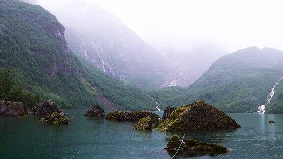 Bondhusvatnet冰川湖被高山和雾蒙蒙的绿色森林环绕下雨天可以乘船游览挪威忧郁的日子里的挪威风景