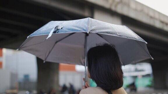 一个亚洲女人在雨中等出租车
