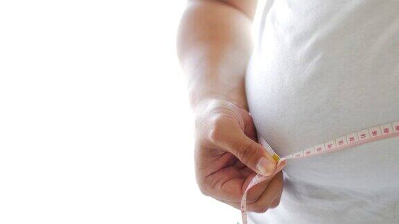 胖人用测量尺测量自己的肚子