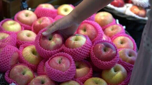 不认识的年轻女子在水果蔬菜超市挑选苹果