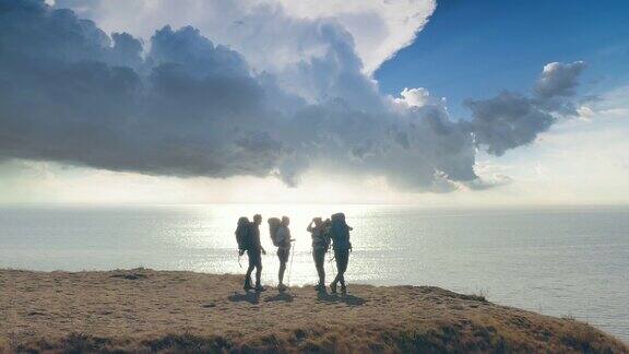 四名游客站在山顶以海景为背景