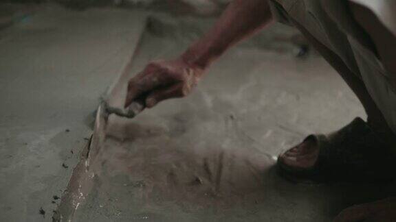 男人的手正在用泥铲抹地板建筑工人在家