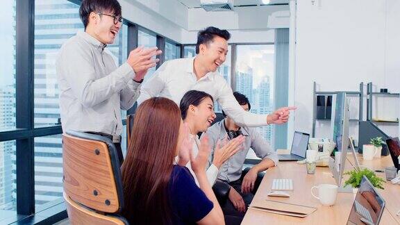 一群亚洲商务人士一起在团队头脑风暴讨论中工作在办公室鼓掌庆祝公司业务同事的团队合作或成功的项目会议概念