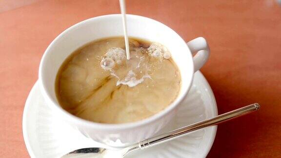 将牛奶倒入白杯中的热红茶中