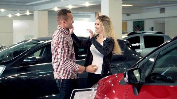 慢动作男人在汽车经销店展示新车给妻子或女友一个惊喜