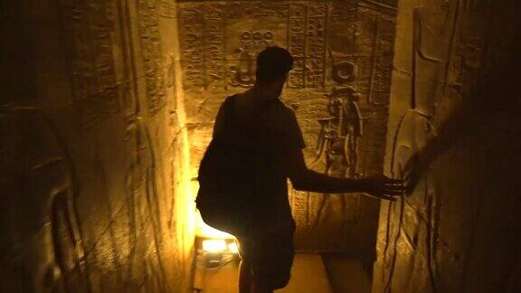 一个年轻人正在参观阿斯旺市附近的Edfu寺庙的隧道埃及飞机从后面跟着在尼罗河河畔的Edfu城希腊罗马建筑献给荷鲁斯