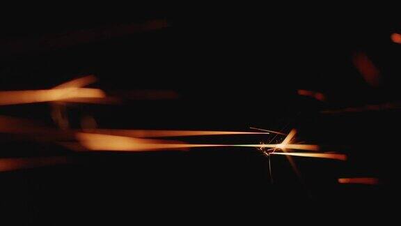 发光流动的金属焊接火花在黑暗中闪耀特写金色的闪光光粒子在黑色的背景上飞行