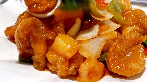 在中餐馆里人们在餐桌上吃炸虾和蔬菜的动作
