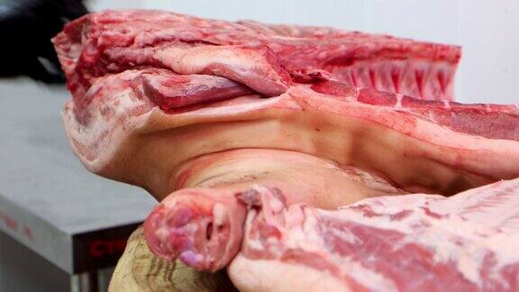 在肉类加工厂屠夫用锋利的斧头切生猪肉