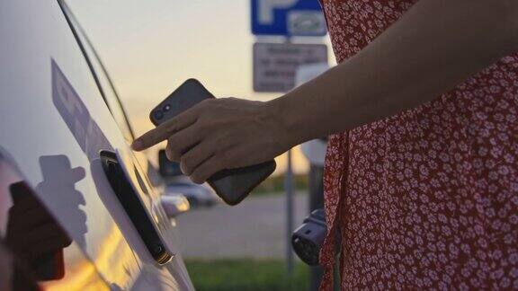 女子在电动汽车充电站为她的电动车充电