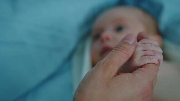 父亲在医院里牵着新生儿的手