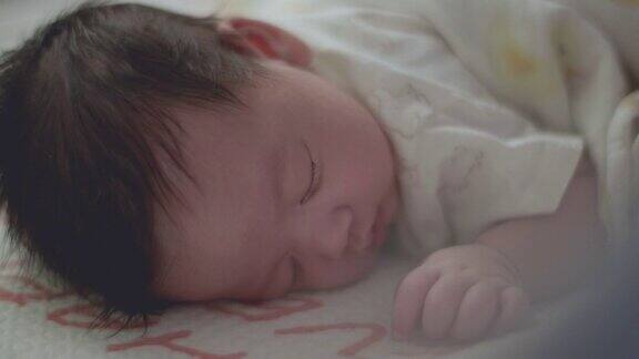 亚洲新生儿在家里的床上睡得很好