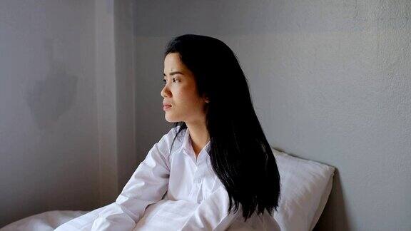 亚洲悲伤的女人坐在卧室的床上