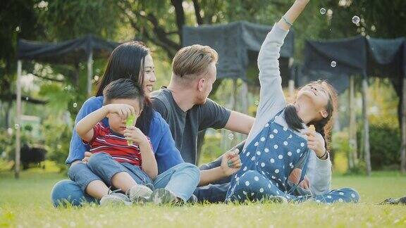 快乐的家庭在户外公园玩肥皂泡