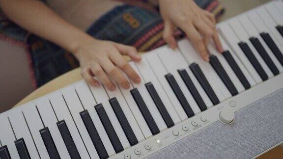 在家独自键盘钢琴爱好年轻女子练习钢琴