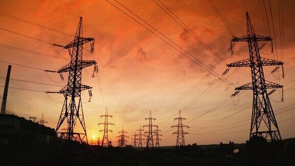 日落时高高的电塔高压电线通过电缆分配电力晚上有金属塔的配电站缓慢的运动