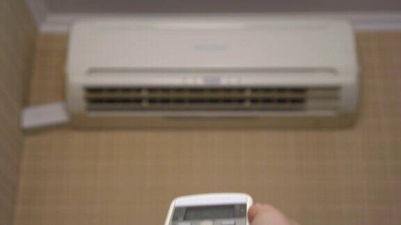 室内空调调节室内温度一位女士用遥控器打开了空调特写镜头空调模糊